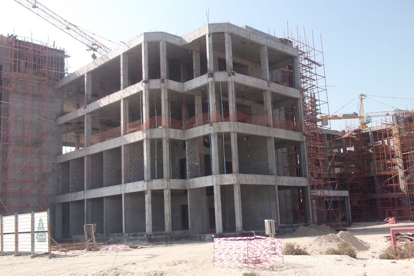 Concrete frame building under construction with tower cranes on a Saudi project site